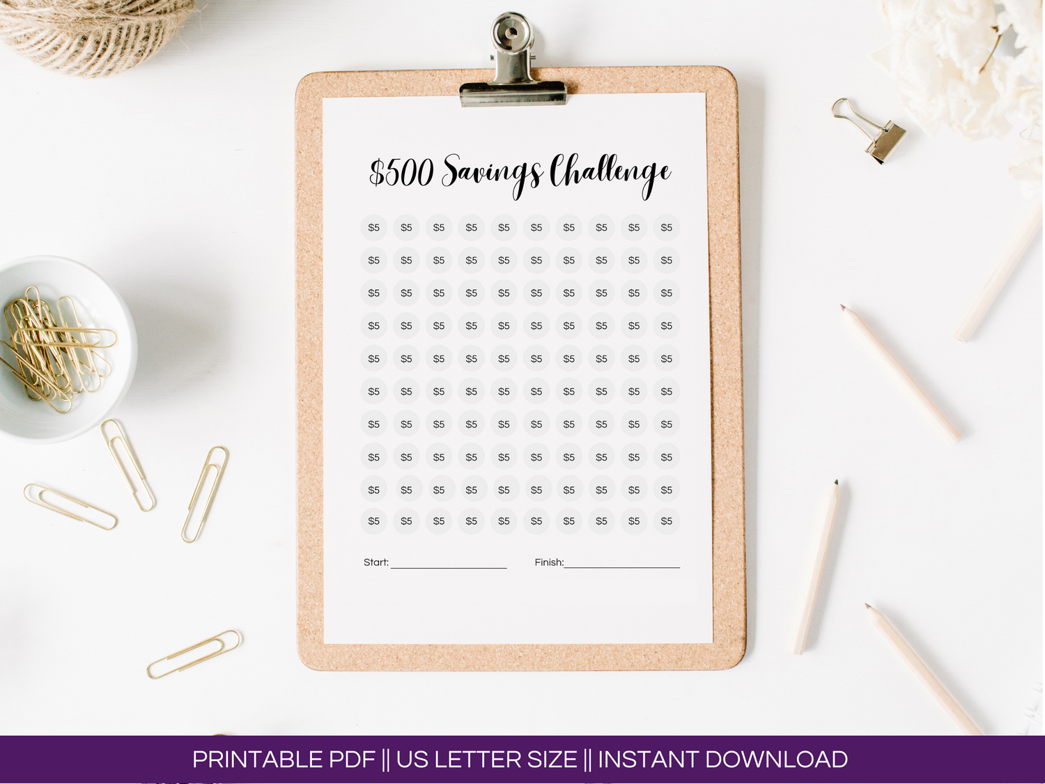 Overhead image of the $500 savings tracker printable on a clipboard with paperclips and pens.